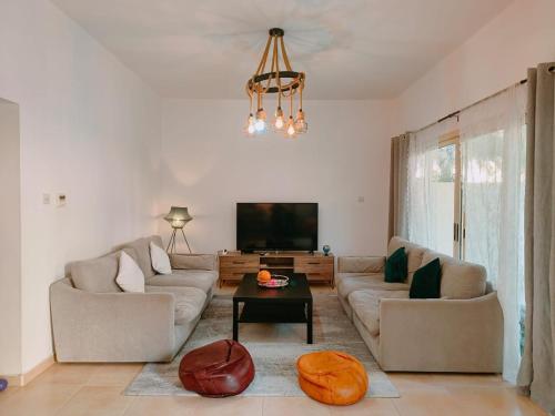a living room with a couch and a tv at Vibe Home in Ras al Khaimah