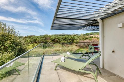 d'un balcon en verre avec des chaises et une vue sur la campagne. dans l'établissement L'Ecrin 103 - Golfe de Saint-Tropez - Happy Rentals, à Sainte-Maxime