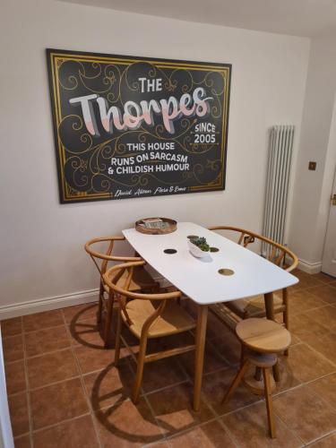 a white table and chairs with a chalkboard on the wall at City Cottage in Lincoln