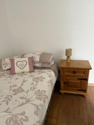 a bedroom with a bed and a wooden night stand at Chez Casa in Sourdeval