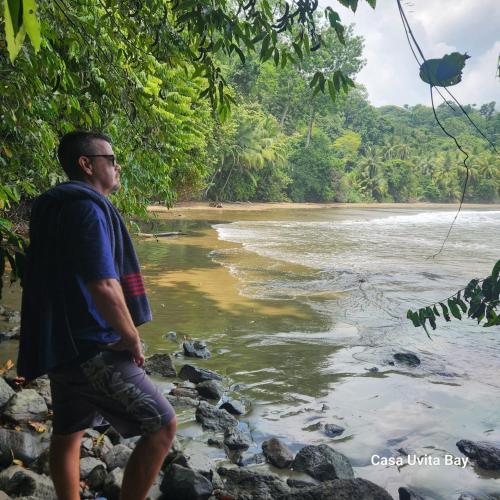 a man standing on the rocks near a river at Casa Uvita Bay in Uvita