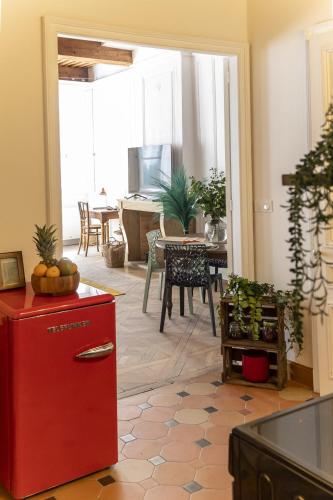 Il comprend une cuisine et une salle à manger avec un réfrigérateur rouge. dans l'établissement Appartement de charme, à Besançon