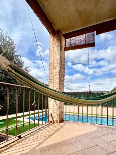 a hammock on a balcony next to a pool at Dos Olivas in Cobisa