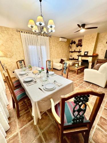 a dining room with a white table and chairs at Dos Olivas in Cobisa