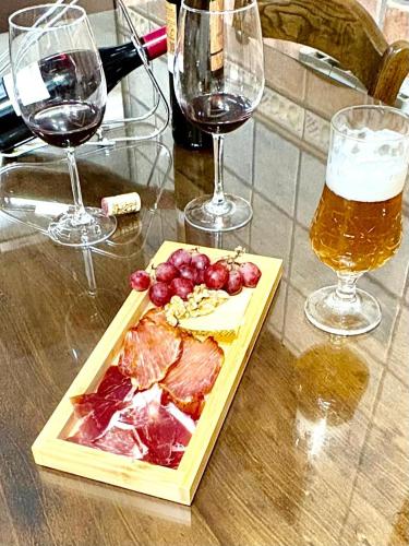 a table with a plate of meat and two glasses of wine at Dos Olivas in Cobisa