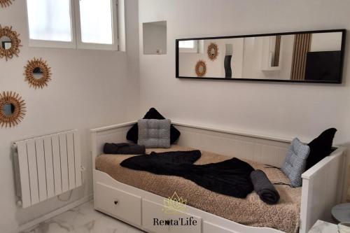 伊西莱穆利诺Appartement Studio, 2 Personnes, 5min de Paris的卧室配有一张带大镜子的床铺,墙上挂有镜子