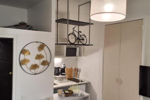 伊西莱穆利诺Appartement Studio, 2 Personnes, 5min de Paris的厨房配有时钟和墙上的镜子