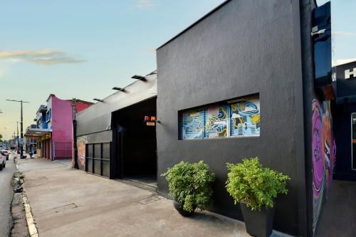 a black building with two potted plants on a sidewalk at HOTEL & HOSTEL RIBEIRAo in Ribeirão Preto