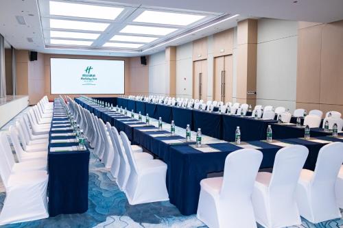 a row of tables and chairs in a room with a screen at Holiday Inn - Nanjing South Station by IHG in Nanjing