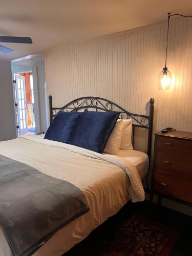 a bedroom with a bed with a blue pillow and a dresser at Downtwn Crystal Terrace Piedmont in Eureka Springs
