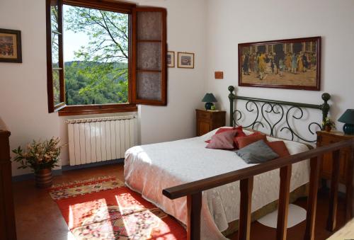 um quarto com uma cama e uma grande janela em Poggio Borgoni em Mercatale Val Di Pesa