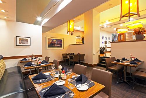 a restaurant with tables and chairs in a room at Crowne Plaza Seattle Newly Renovated with No Resort Fee in Seattle