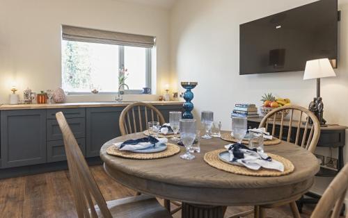 a dining room table with chairs and a kitchen at Castlestone Holiday Cottages & Townhouses in Naas
