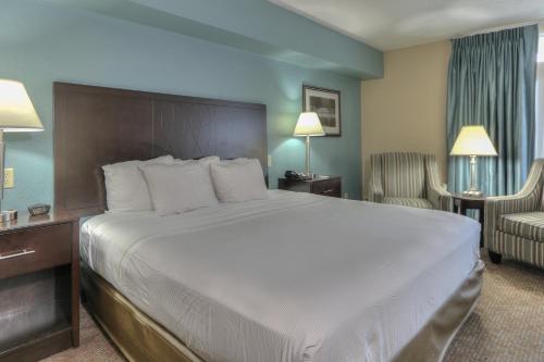 a hotel room with a large bed and a chair at Greystone Lodge on the River in Gatlinburg