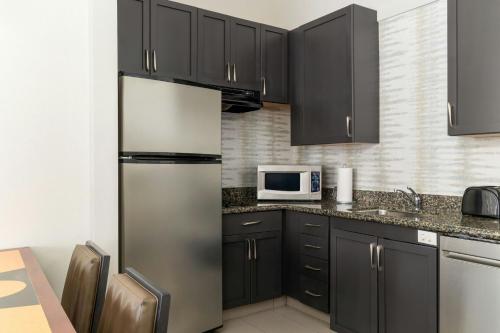 a kitchen with black cabinets and a stainless steel refrigerator at Residence Inn by Marriott Fredericksburg in Fredericksburg