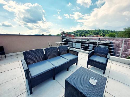 a patio with chairs and tables on a balcony at GFS way studios - greenline accomodation in Ljubljana