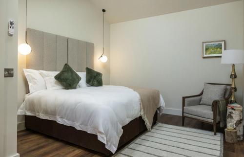 a bedroom with a large bed and a chair at Castlestone Holiday Cottages & Townhouses in Naas