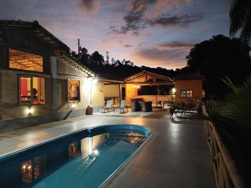 una casa con piscina delante de una casa en Pousada Paudório, en Conceição do Mato Dentro