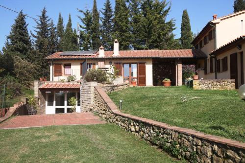 una casa con una pared de piedra y un patio en Vigna Lontana, en Montescudaio