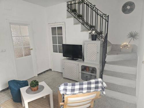 a living room with a staircase with a television at Casa Borete in Olvera