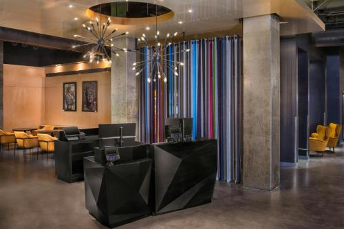 a lobby with a waiting room with yellow chairs at Aloft - Tampa Downtown in Tampa