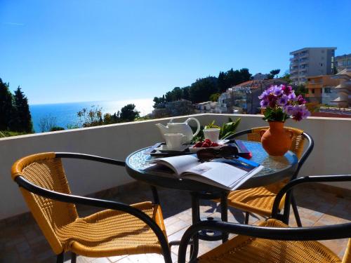 una mesa y sillas en un balcón con vistas al océano en Apartments Lungo Mare Ulcinj, en Ulcinj
