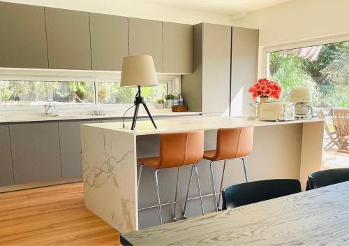 a kitchen with a counter with chairs and a lamp at Pomar da Choca Country House in Alenquer