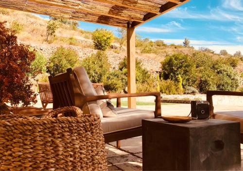 a porch with a couch and a table with a table at Pomar da Choca Country House in Alenquer