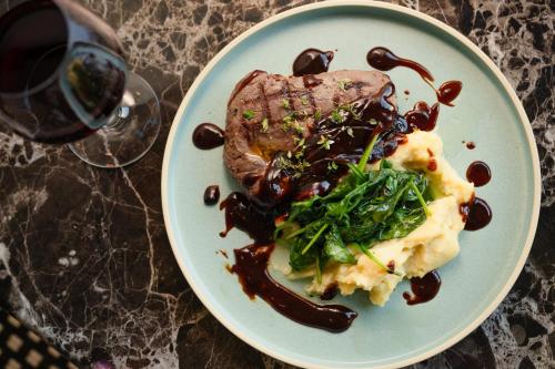 a plate of food with meat and vegetables on a table at Holiday Inn Sydney Potts Point in Sydney