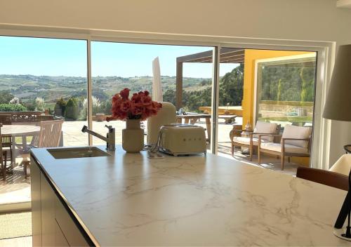 a kitchen with a counter with a view of a patio at Pomar da Choca Country House in Alenquer