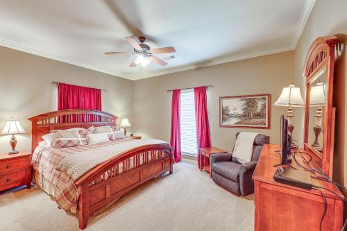 ein Schlafzimmer mit einem Bett, einem Fernseher und einem Stuhl in der Unterkunft Private Dock The River House in Heber Springs! in Heber Springs