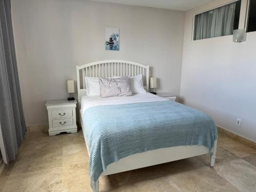 a bedroom with a bed with a blue comforter at Modern Apartments Ocean Reserve Sunny Isles Beach in Sunny Isles Beach