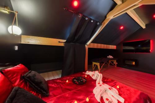 Cette chambre dispose d'un lit rouge et d'un plafond noir. dans l'établissement Nid d'amour romantique, à Corbeil-Essonnes