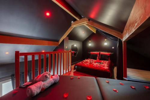 - une chambre dotée d'un lit rouge avec un ours en peluche dans l'établissement Nid d'amour romantique, à Corbeil-Essonnes