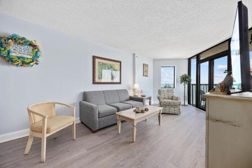 a living room with a couch and a table at Family-Friendly Oceanfront Condo at Compass Cove Resort in Myrtle Beach in Myrtle Beach