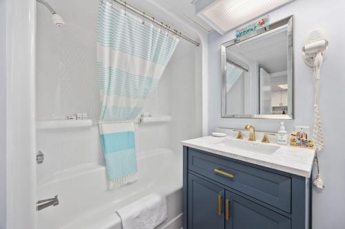 a bathroom with a white tub and a sink and a mirror at Family-Friendly Oceanfront Condo at Compass Cove Resort in Myrtle Beach in Myrtle Beach