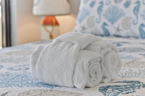 a pile of towels sitting on top of a bed at Family-Friendly Oceanfront Condo at Compass Cove Resort in Myrtle Beach in Myrtle Beach