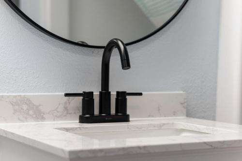 a bathroom sink with a faucet and a mirror at Charming 3BR 2BA Oceanfront Condo in Myrtle Beach