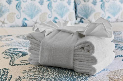 a stack of towels sitting on a bed at Charming 3BR 2BA Oceanfront Condo in Myrtle Beach