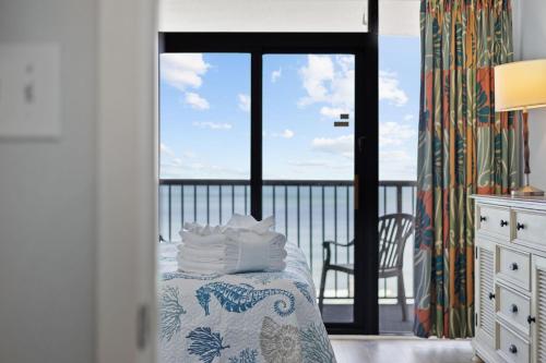 a bedroom with a bed with a view of the ocean at Charming 3BR 2BA Oceanfront Condo in Myrtle Beach