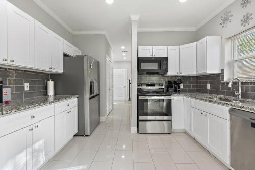 a large white kitchen with white cabinets and appliances at Game Room & Event Open Luxury Haven in Dallas