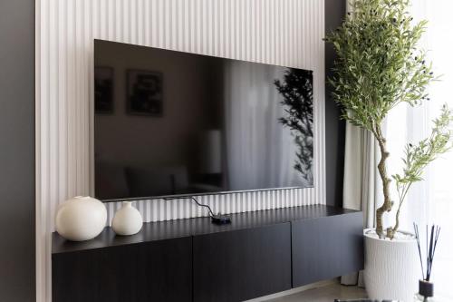 a television on a black cabinet in a living room at Tranquil 1BR Hideaway in Damac Hills in Dubai Marina