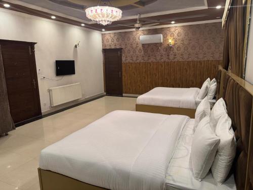 a bedroom with two beds and a tv in it at Comfort Family Villa Islamabad in Islamabad