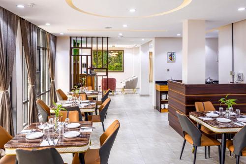 Executive Hotel and Suites في إيكيجا: مطعم بطاولات وكراسي خشبية