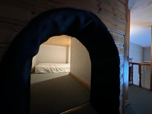 a bedroom with an archway with a bed in it at Hargate Hall Self Catering in Buxton