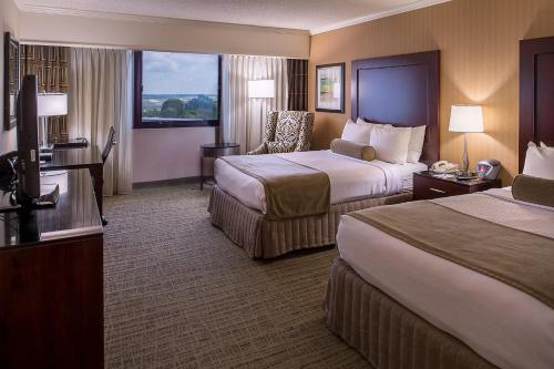 a hotel room with two beds and a television at Crowne Plaza Hotel St. Louis Airport by IHG in Bridgeton