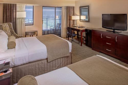 a hotel room with two beds and a flat screen tv at Crowne Plaza Hotel St. Louis Airport by IHG in Bridgeton