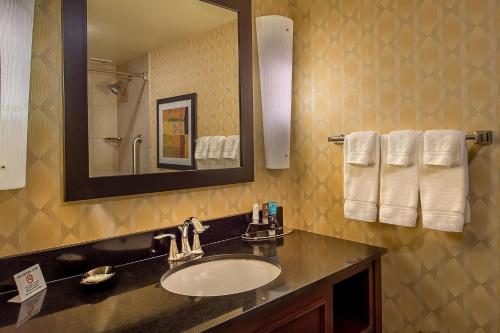 a bathroom with a sink and a mirror and towels at Crowne Plaza Hotel St. Louis Airport by IHG in Bridgeton