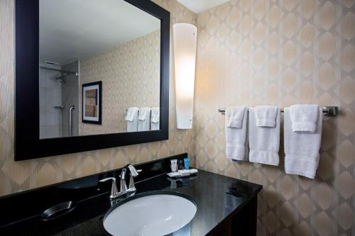 a bathroom with a sink and a mirror and towels at Crowne Plaza Hotel St. Louis Airport by IHG in Bridgeton