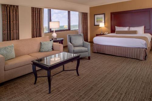 a hotel room with a bed and a couch and a table at Crowne Plaza Hotel St. Louis Airport by IHG in Bridgeton
